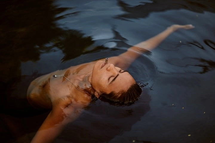 A Man Lying In Water Using Lovetuner with his mouth