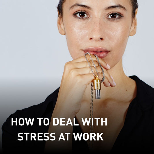 Woman holding a Lovetuner to her lips, looking directly into the camera. Text overlay: 'How to Deal with Stress at Work