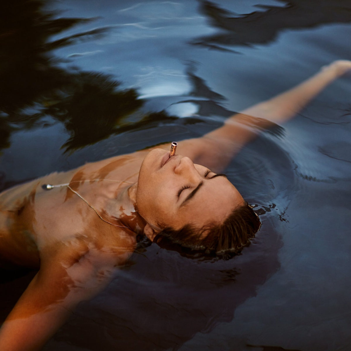 Person floating in water breathing through a Lovetuner 528Hz breathing necklace