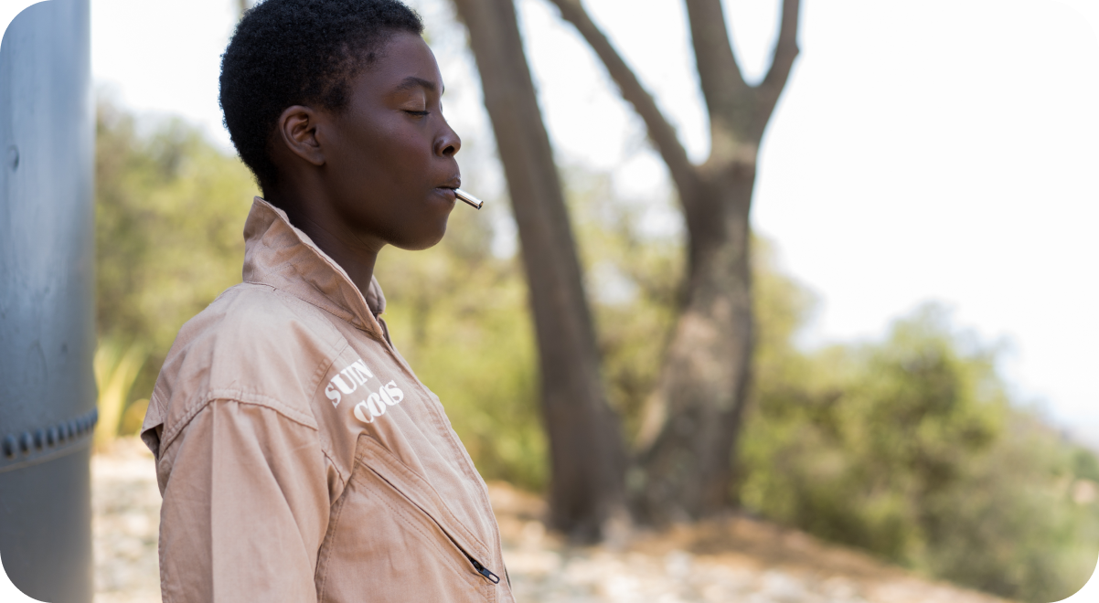 A woman using a Lovetuner against a blurry background of a tree and mountain