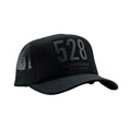 Carica l'immagine nel visualizzatore della galleria, Black trucker cap with '528' and brand name on a white background

