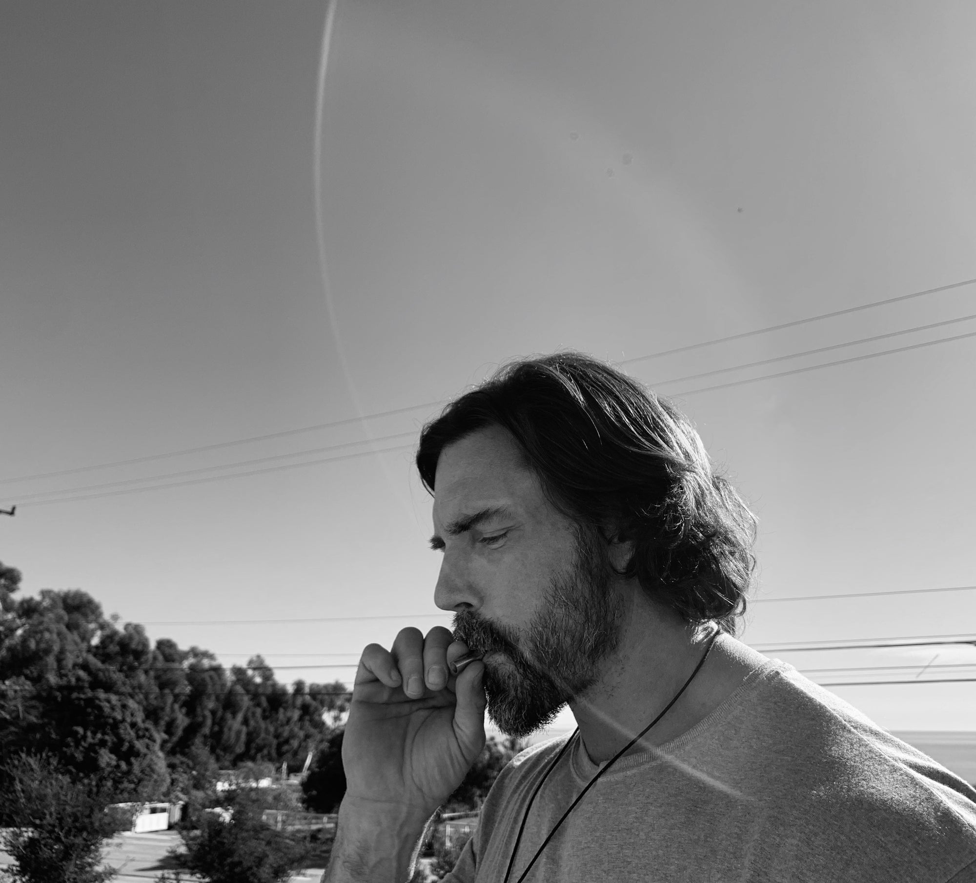 A black and white photo of a man with a beard using the Lovetuner