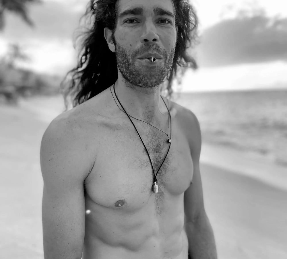 A black and white photo of a shirtless man on the beach using the Lovetuner