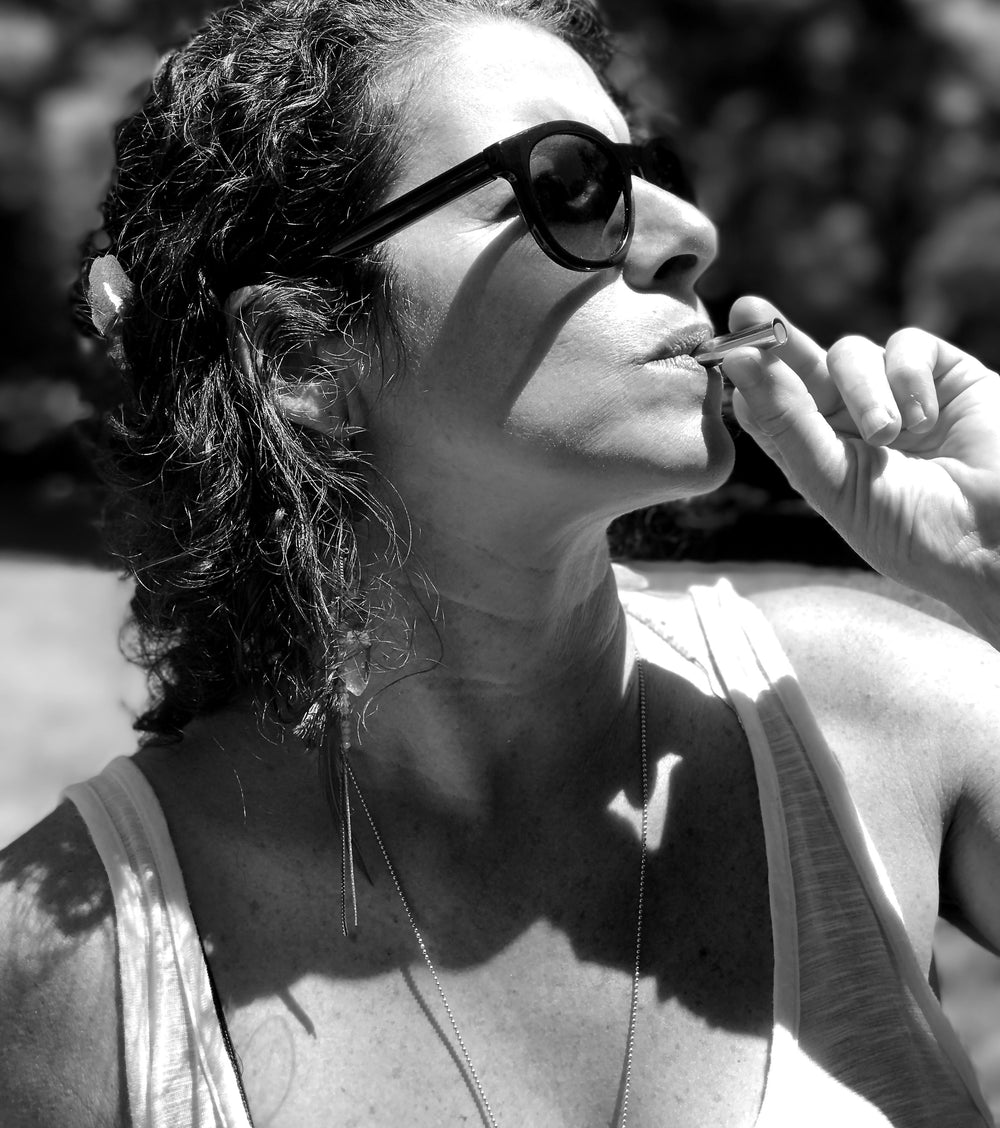 A black and white photo of a woman in a tank top and sunglasses using the Lovetuner