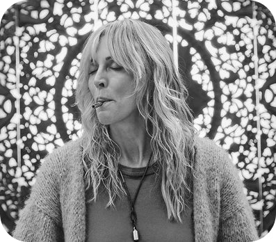 A black and white photo of a woman using the Lovetuner against a patterned background