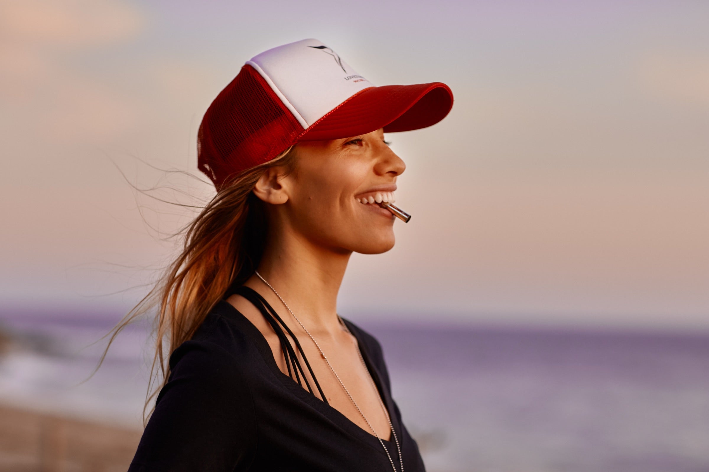 Una mujer junto al agua al atardecer, respirando con su Lovetuner